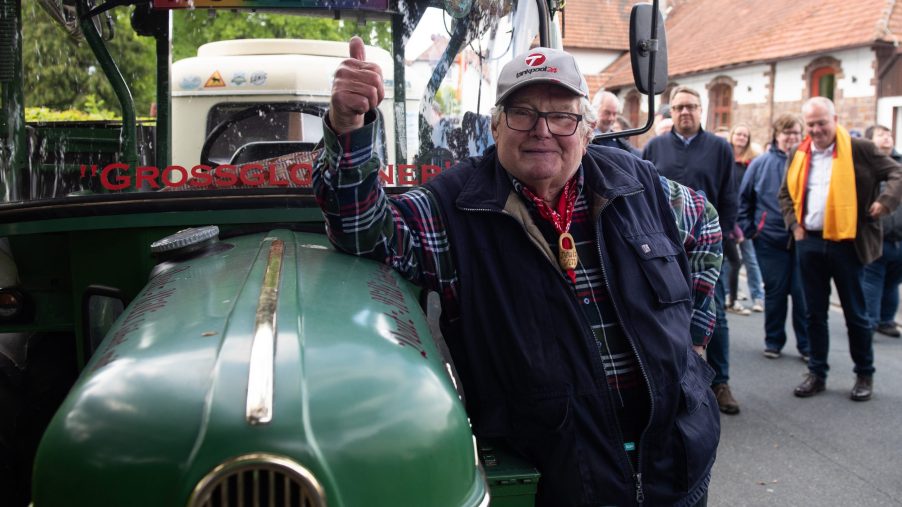 The pensioner Winfried Langner, known as "Deutz-Willi", stands next to his tractor before the descent