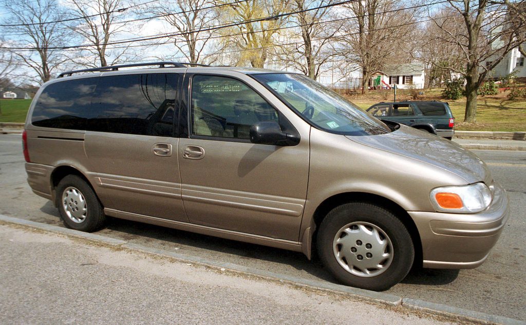A beige Oldsmobile Silhouette minivan sits parked on a street in April 2001