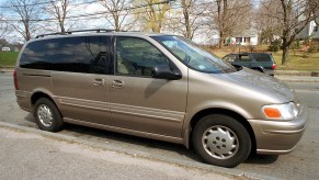 A beige Oldsmobile Silhouette minivan sits parked on a street in April 2001