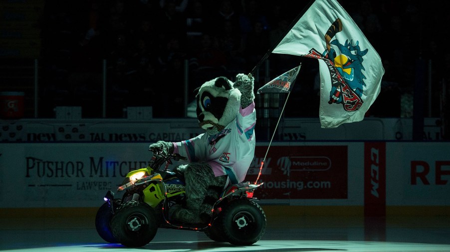 Rocky Raccoon, the mascot of the Kelowna Rockets, rides onto the ice on his Polaris Outlaw quad while flying the flag against the Prince George Cougars at Prospera Place on November 29, 2017, in Kelowna, Canada.