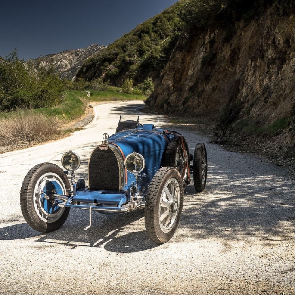 A blue Pur Sang Bugatti Type 35 replica on a rocky trail