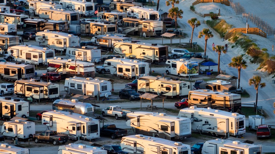 Motorhome and travel trailer RVs parked in Myrtle Beach Travel Park in South Carolina near sunset.