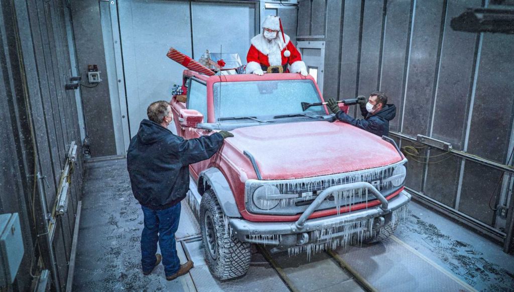 Santa stands in the back of the 2021 Ford Bronco's discussing cold weather testing results with two engineers | Ford Motor Company