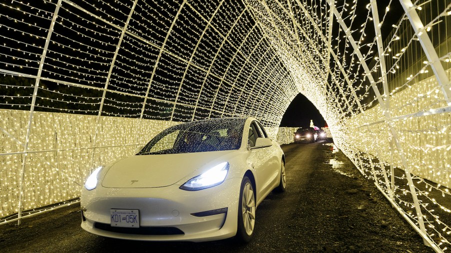An electric vehicle passes through a Christmas light tunnel display at the Christmas Glow in Langley: Drive-Through Holiday Light Event at Milner Village Garden Centre on December 11, 2020, in Langley, British Columbia, Canada.