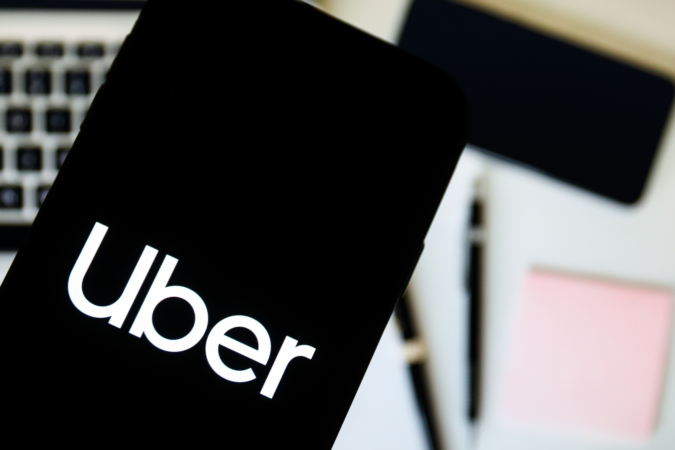 In this photo illustration a Uber company logo seen displayed on a smartphone