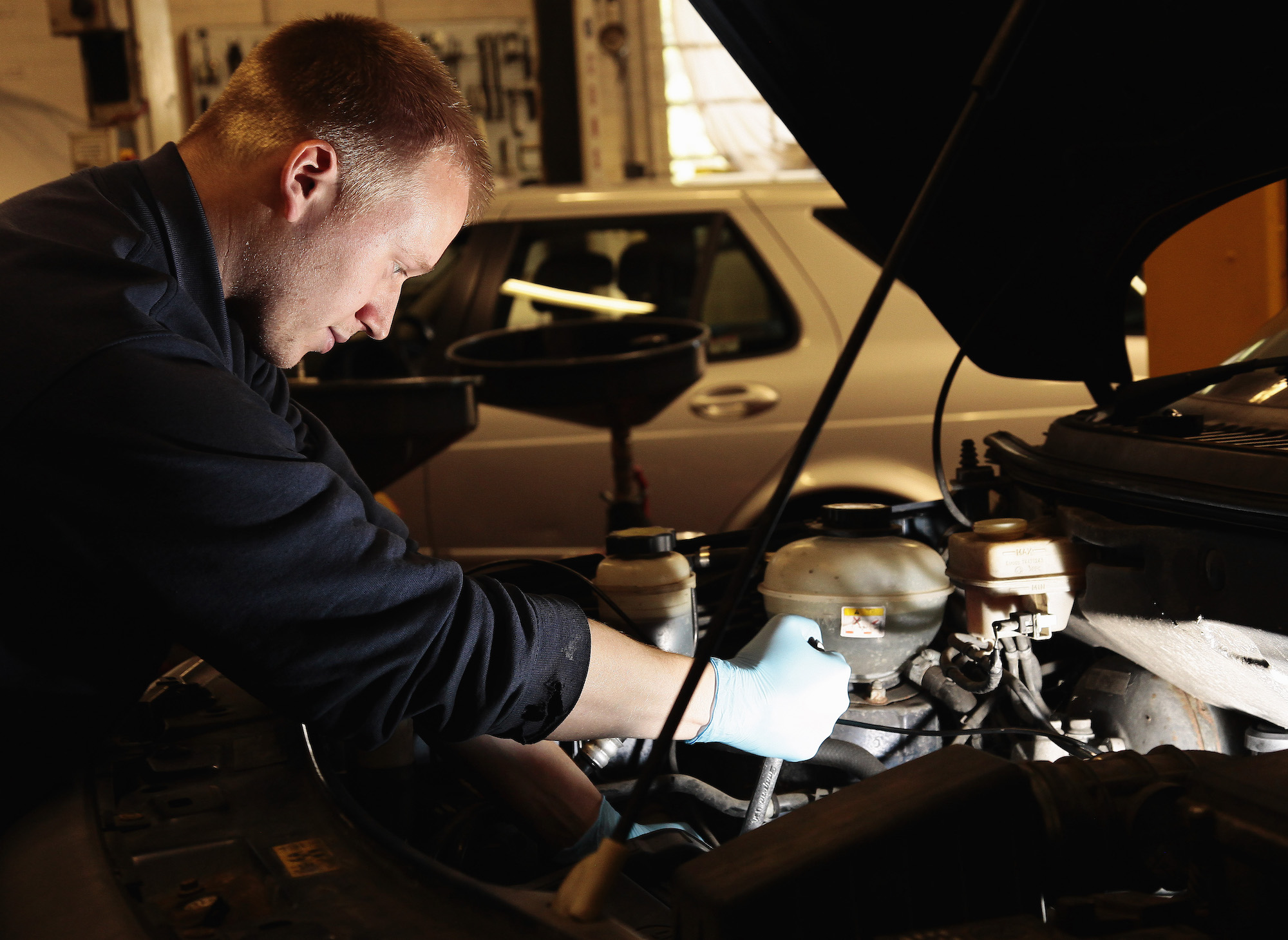 A mechanic works on a car in a garage