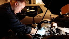 A mechanic works on a car in a garage