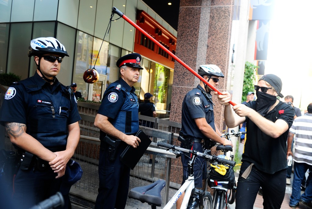 protester dangling donut in front of cop