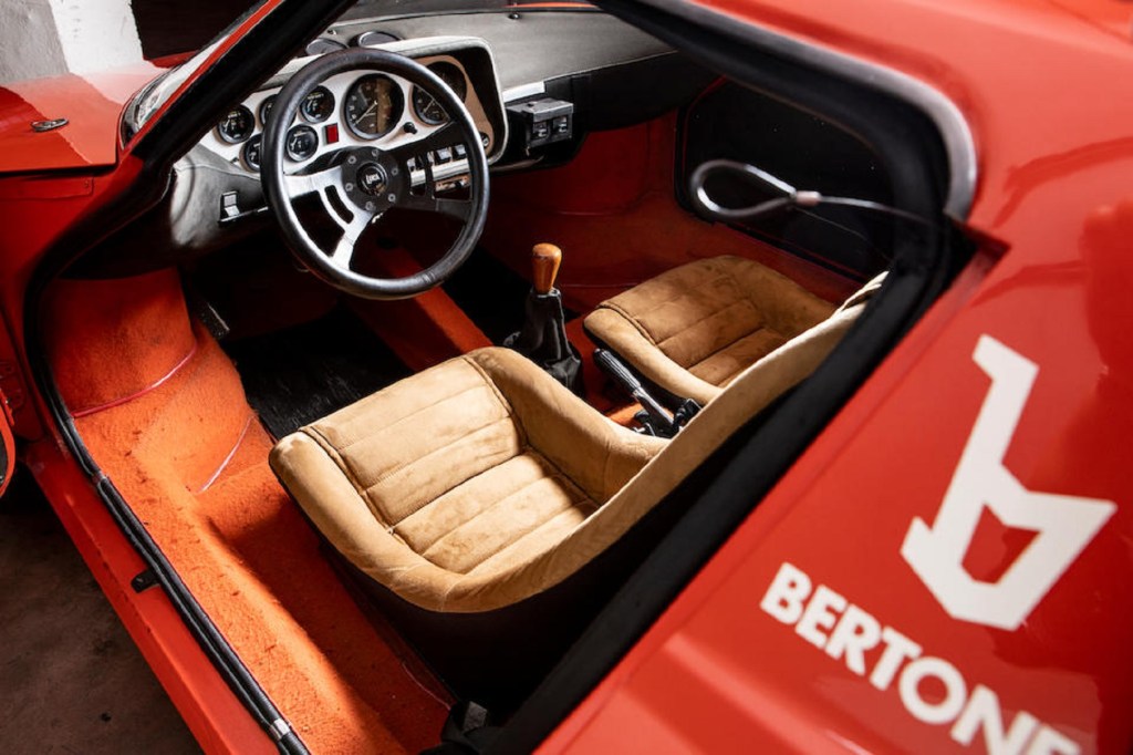 The tan-leather seats and the dashboard of a red 1974 Lancia Stratos HF Stradale