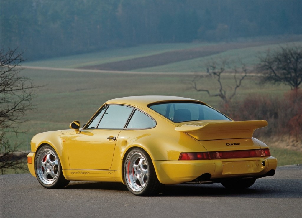 The rear 3/4 view of a yellow 1992 Porsche 911 Turbo S 3.3 and its 'whaletail' spoiler