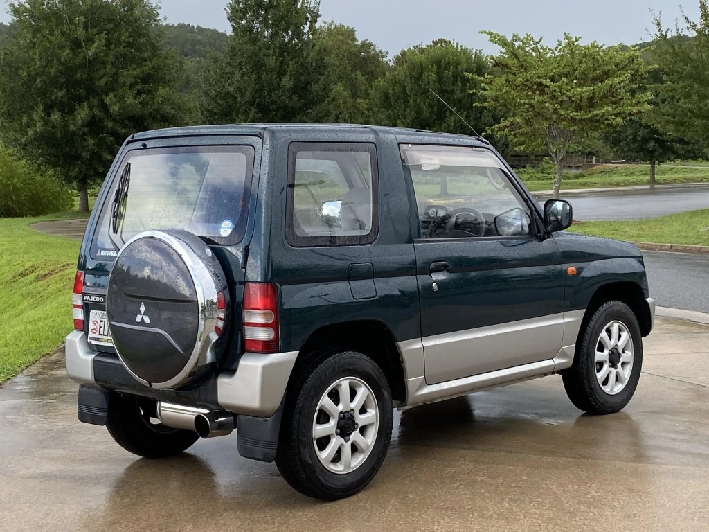 The rear 3/4 view of a dark-green 1995 Mitsubishi Pajero Mini VR-II