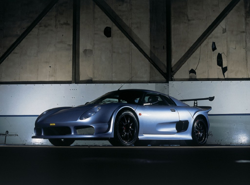 A silver 2004 Noble M400 in a dark warehouse