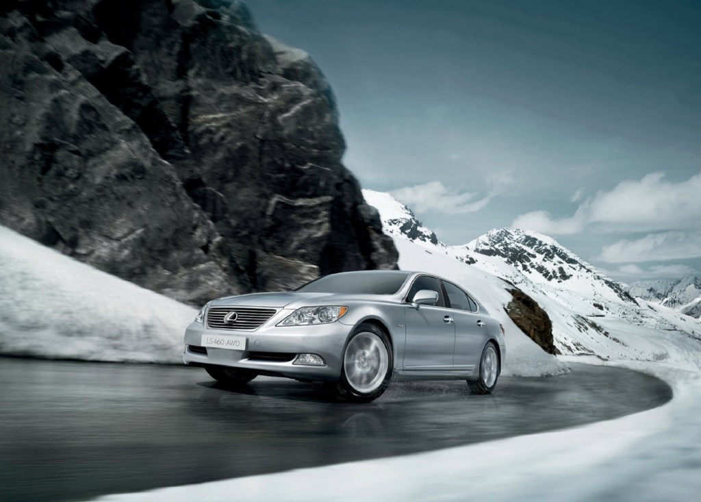 A silver 2009 Lexus LS 460 AWD drives up a wet snowy mountain road