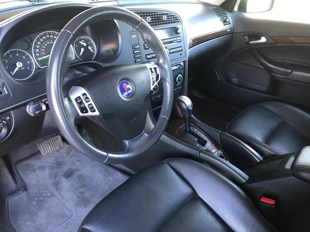 The black dashboard and black-leather front seats of a 2009 Saab 9-3 SportCombi 2.0T
