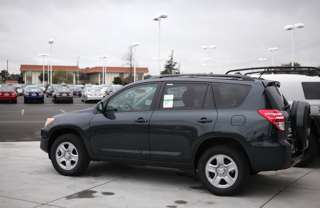 A blue 2012 Toyota RAV4 parked on display at a dealership lot