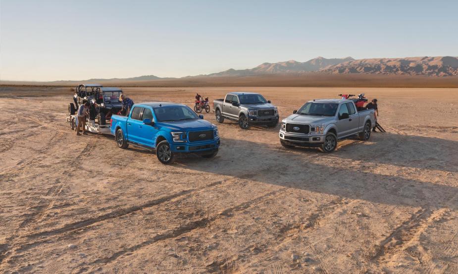 Three Ford F-150 Lariat XLT pickup trucks parked in a desert. The F-150 is part of Ford's F-Series of trucks.