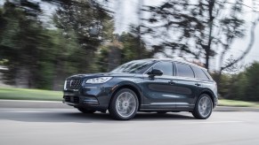 A blue 2020 Lincoln Corsair Grand Touring driving down a city road