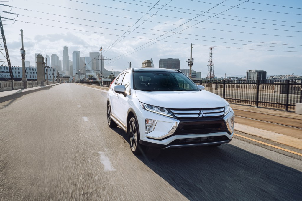 A white 2020 Mitsubishi Eclipse Cross driving down a city road