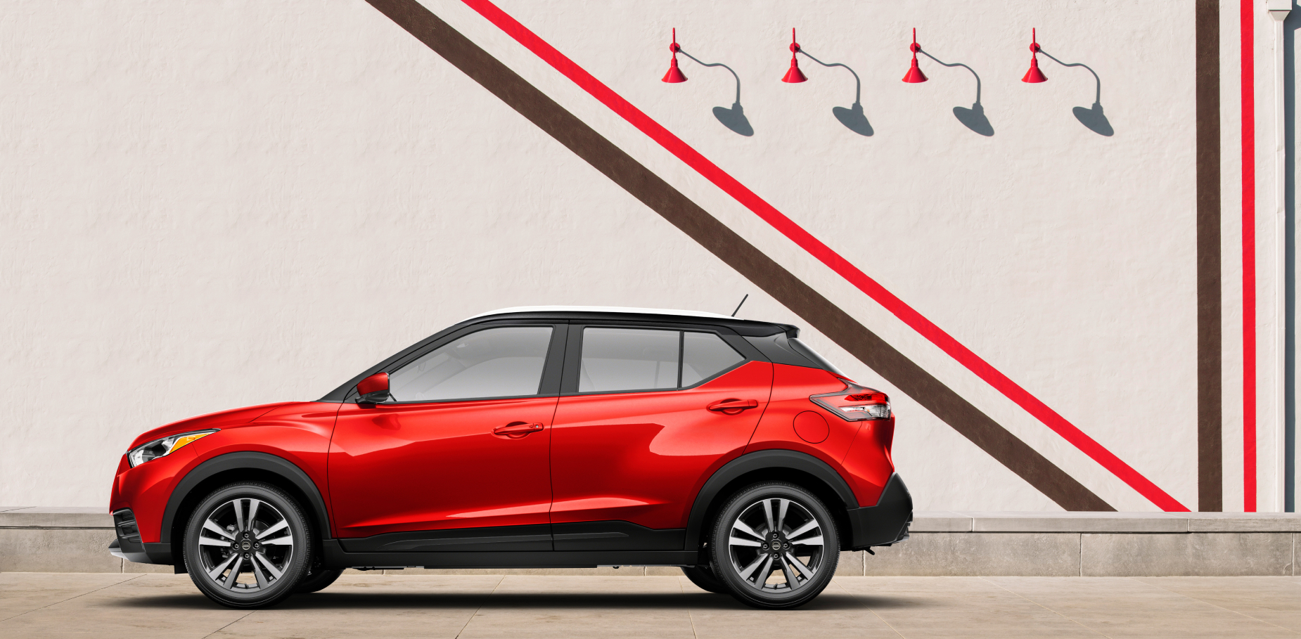 A red 2020 Nissan Kicks parked next to an artsy wall