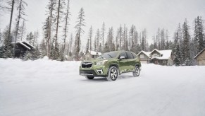 A green 2020 Subaru Forester driving through a snowy road