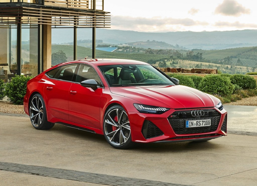 A red 2021 Audi RS7 overlooking a forest mountain