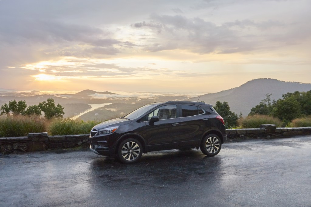 A black 2021 Buick Encore on display in front of mountain range