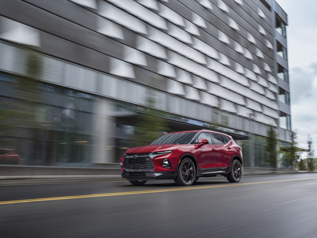 A red 2021 Chevrolet Blazer family SUV safely driving down a city road