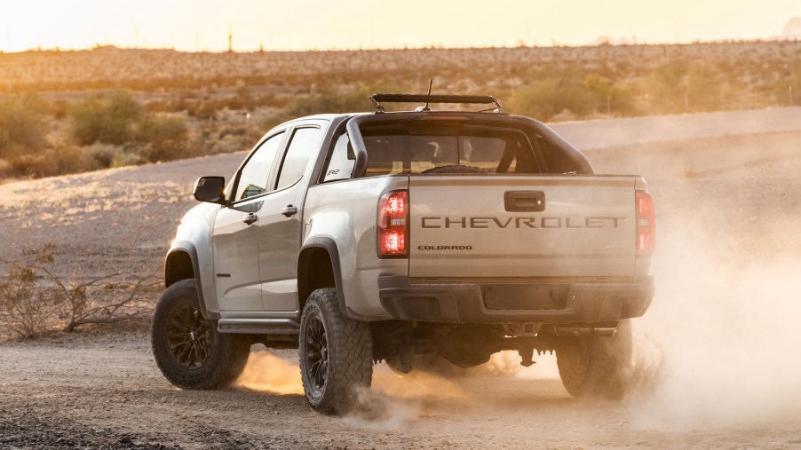 A silver 2021 Chevrolet Colorado ZR2 kicks up some dust on a dirt road