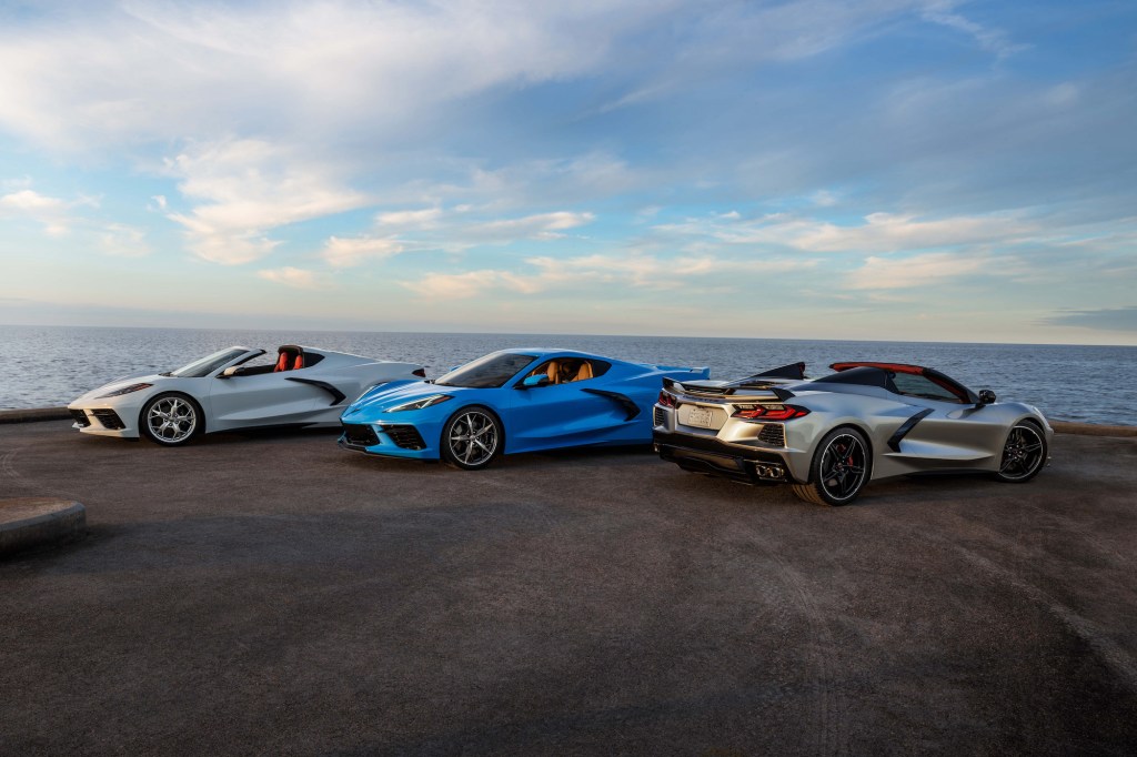 Three 2021 Chevy Corvette Stingray coupe and convertible models overlooking an ocean