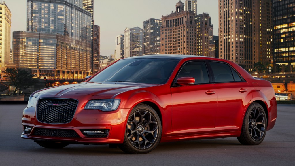 A red 2021 Chrysler 300 on display with a cityscape in the background