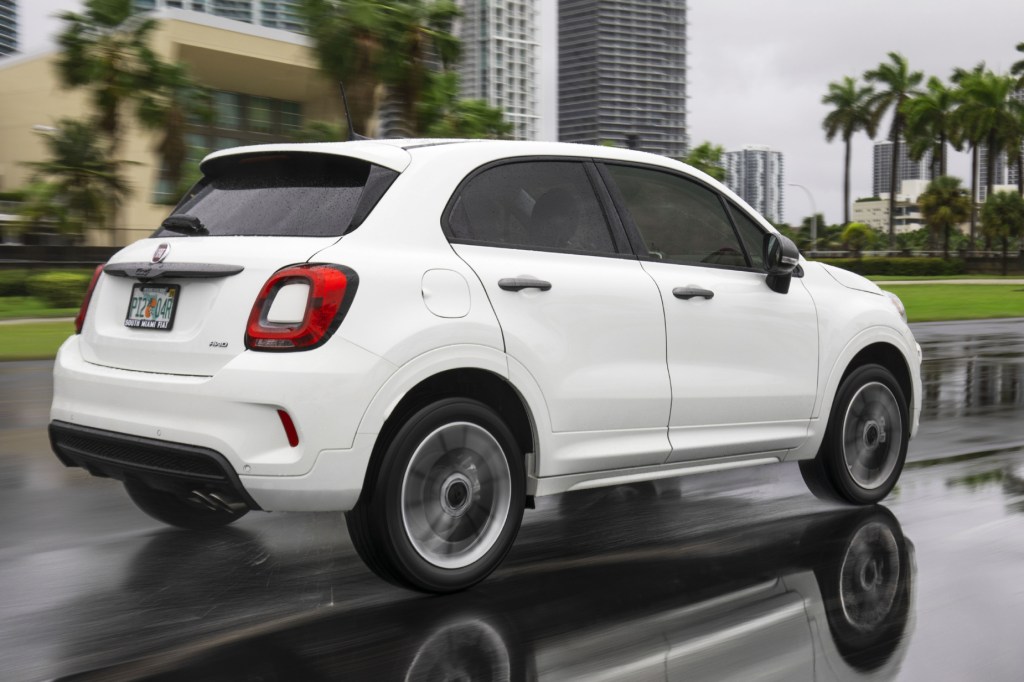 A white 2021 Fiat 500X subcompact SUV driving down a city road
