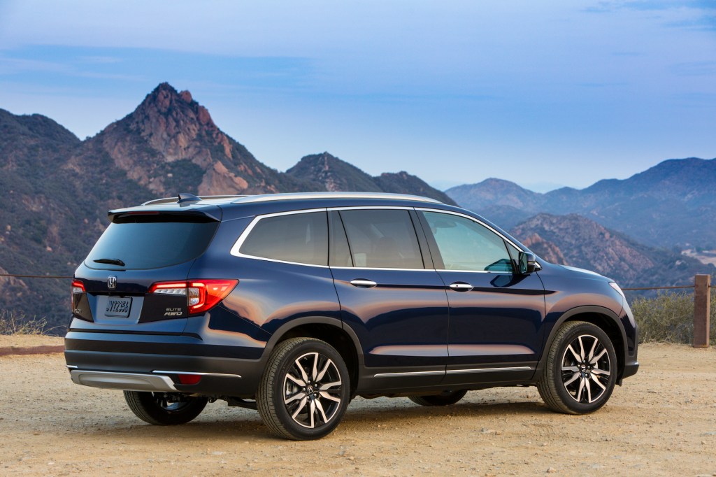 A dark-colored 2021 Honda Pilot Elite overlooks mountains