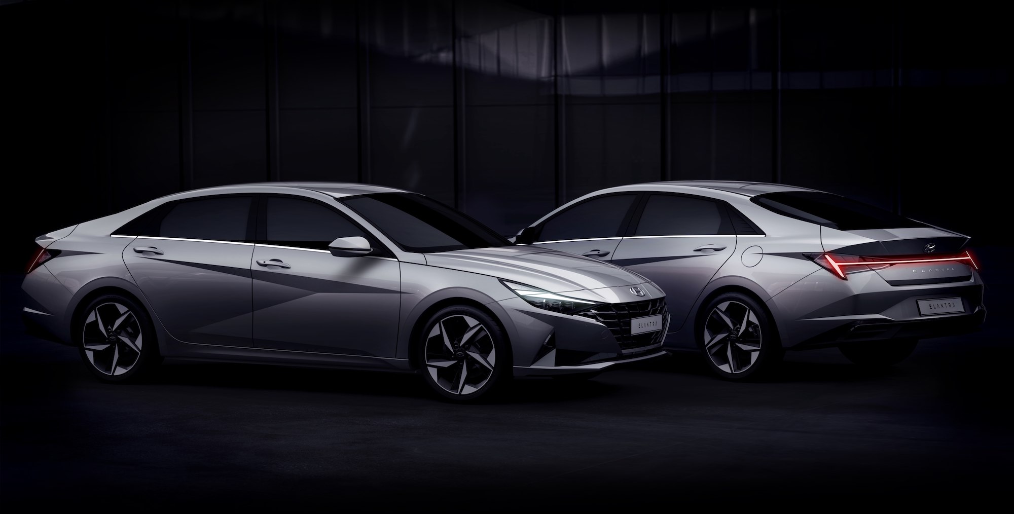2 silver Hyundai Elantra sedans parked in the dark