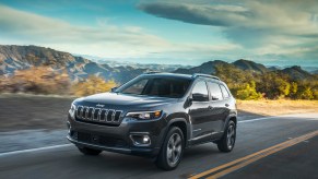 2021 Jeep® Cherokee Limited driving down a sunlit roadway