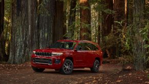 A red 2021 Jeep Grand Cherokee L Overland in a forest