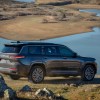 A dark-gray 2021 Jeep Grand Cherokee L Summit Reserve parked overlooking a lake and mountains
