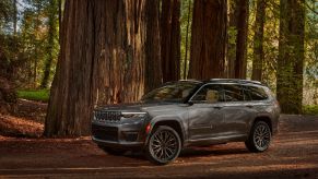 A gray 2021 Jeep Grand Cherokee L Summit Reserve in a forest
