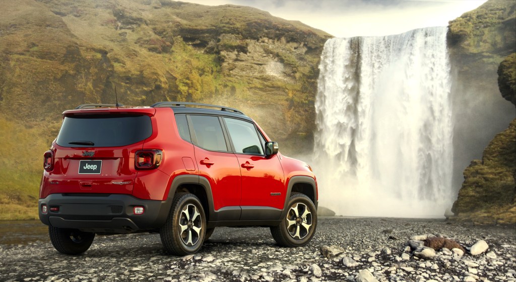 A red 2021 Jeep Renegade subcompact SUV parked next to a waterfall
