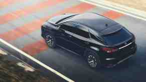 A black 2021 Lexus RX350 travels on a paved strip painted with red lines