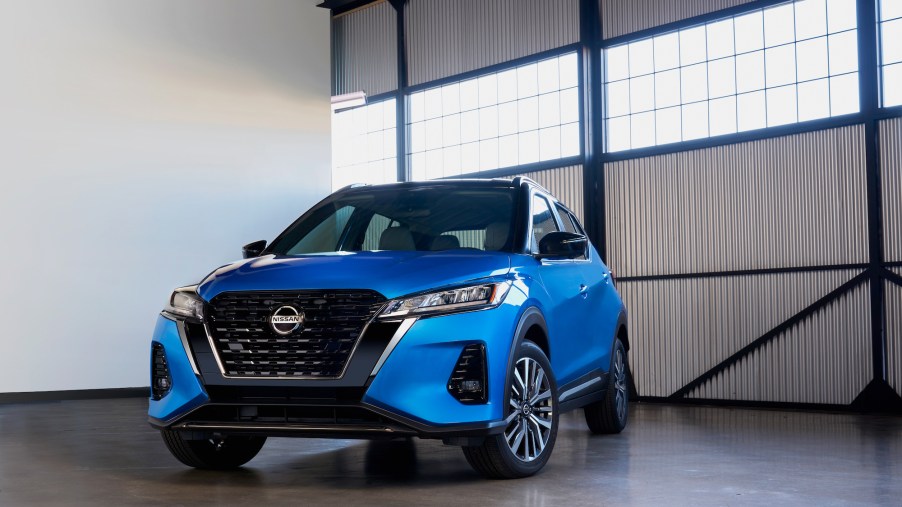 A blue 2021 Nissan Kicks subcompact crossover SUV parked in a bare garage