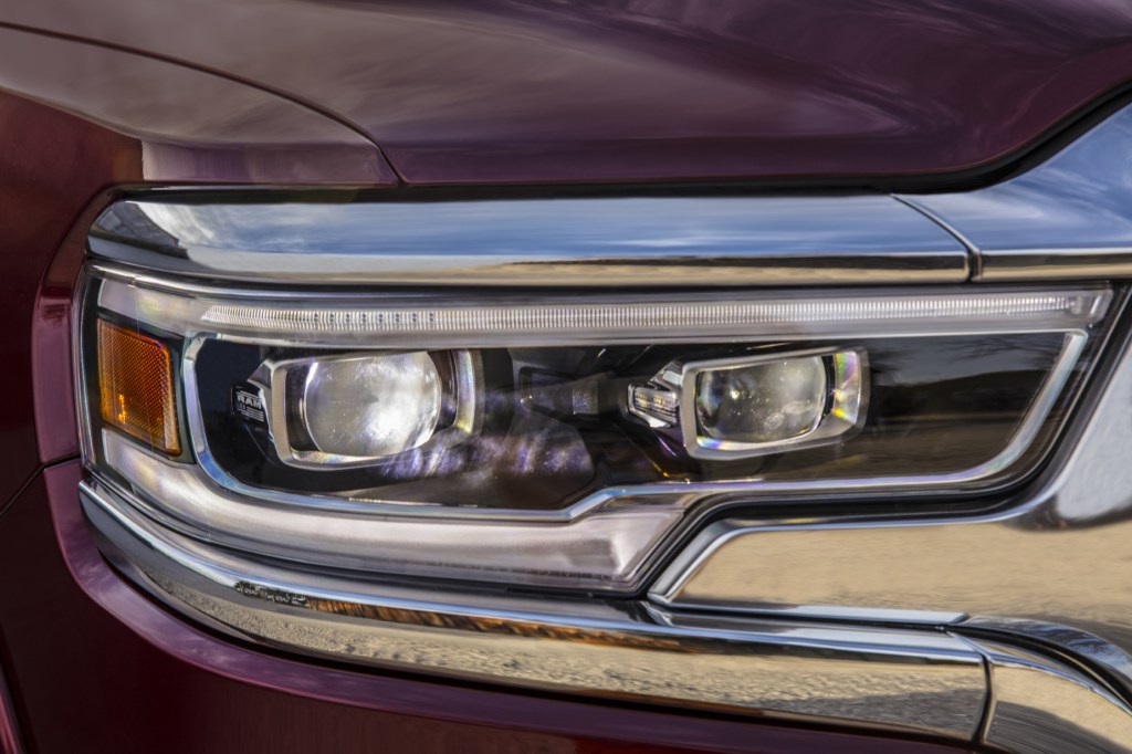 A close-up look at the headlights of a red 2021 Ram 1500 Limited