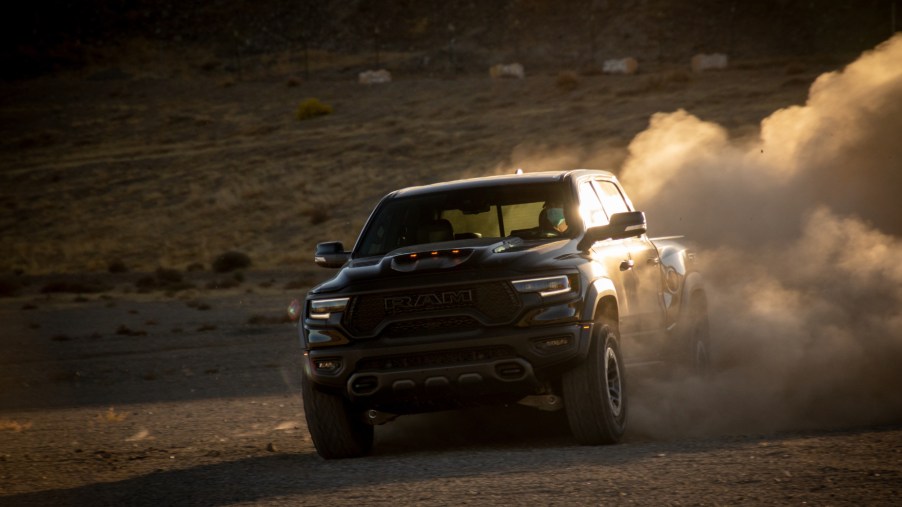 A black 2021 Ram 1500 TRX driving off-road with dirt kicking up