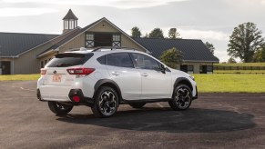 A 2021 Subaru Crosstrek Limited in Crystal White Pearl parked on gravel in front of a barn