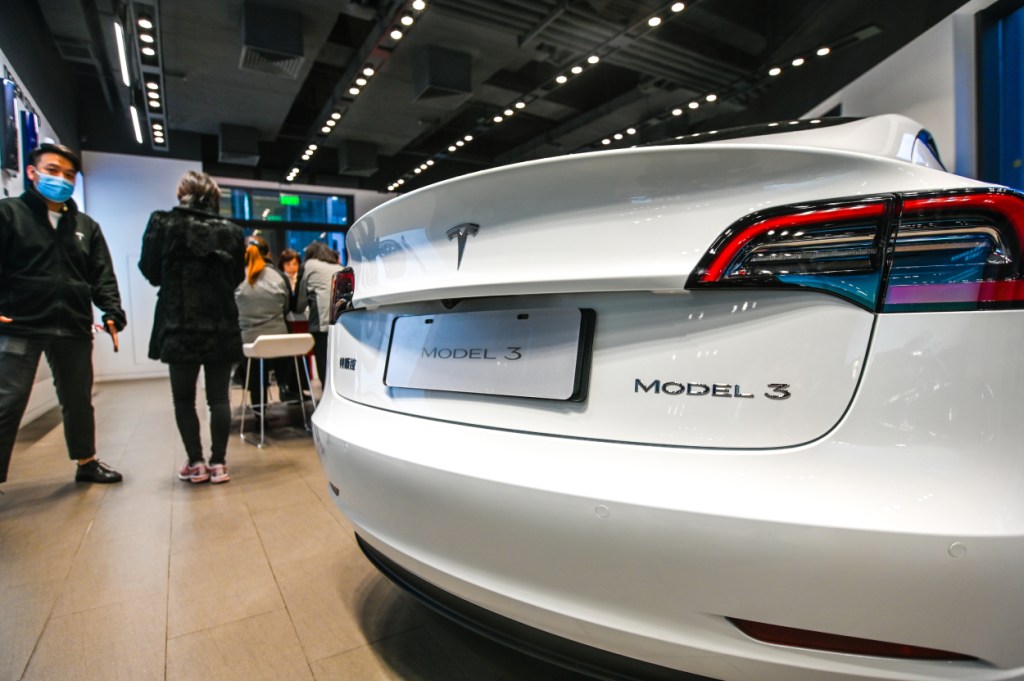 A close-up of the Tesla Model 3 on display in a small showroom