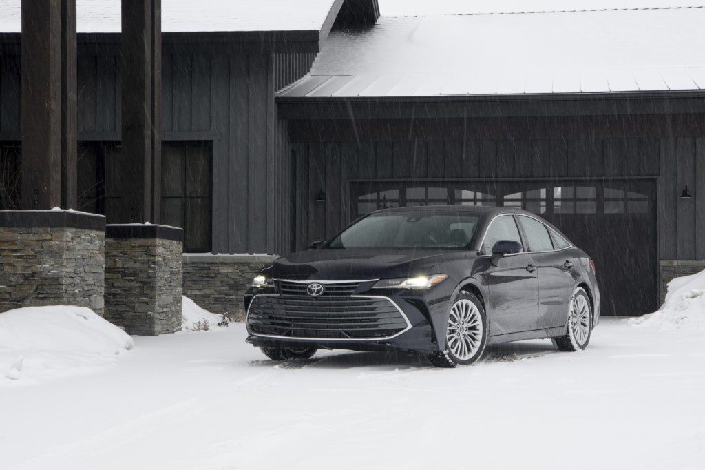 A black 2021 Toyota Avalon Limited AWD surrounded by snow in a driveway