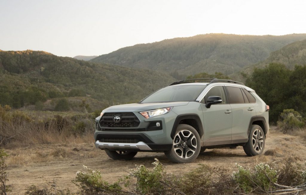 A green 2021 Toyota RAV4 parked with a mountain in the background