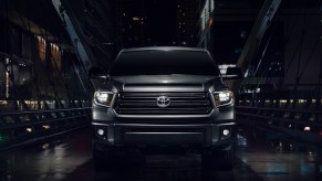 Front view of a black 2021 Toyota Tundra Nightshade on a city bridge at night