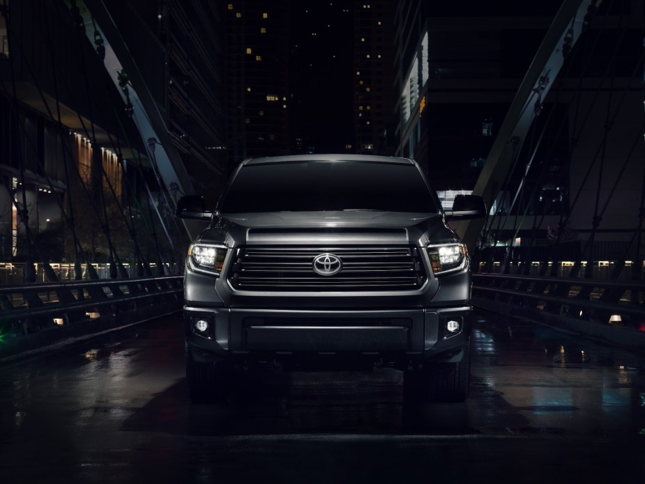 Front view of a black 2021 Toyota Tundra Nightshade on a city bridge at night