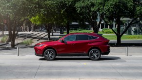 A dark-red 2021 Toyota Venza LE stopped on a city street