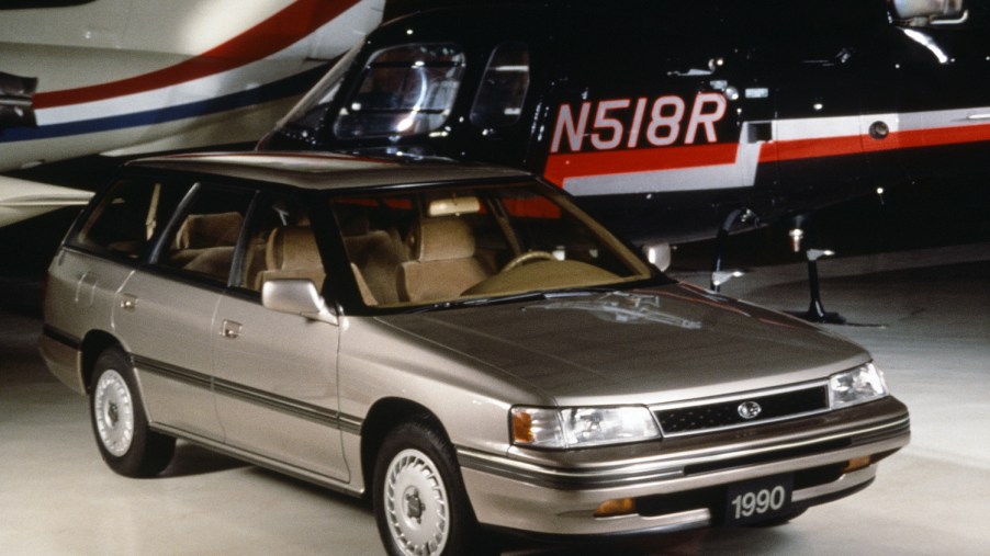 1990 Subaru Legacy wagon parked in front of a plane